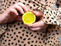 Young beautiful woman holding a fresh yellow lemon in her hands, close-up summer fruit concept Royalty Free Stock Photo