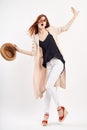 Young beautiful woman holding a hat on a white background, full-length, fashion