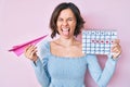 Young beautiful woman holding heart calendar and paper airplane sticking tongue out happy with funny expression Royalty Free Stock Photo