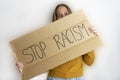 Young beautiful woman holding a protest poster with the text Stop Racism.Politics and social problems concept, anti racial