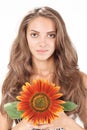 Young beautiful woman holding sunflower near face