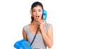 Young beautiful woman holding vintage telephone scared and amazed with open mouth for surprise, disbelief face Royalty Free Stock Photo