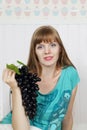 Young beautiful woman holds black grape