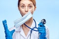 Young beautiful woman holds a stethoscope in medical clothes on a blue background, portrait, doctor, emotions, medicine Royalty Free Stock Photo