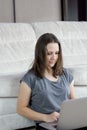 Young beautiful woman at home sitting on the floor with laptop