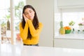 Young beautiful woman at home on white table sleeping tired dreaming and posing with hands together while smiling with closed eyes Royalty Free Stock Photo