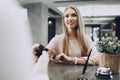 Young beautiful woman hotel guest paying for her stay with credit card at front desk