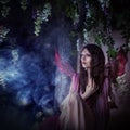 Young beautiful woman in the image of fairies, magic dark forest