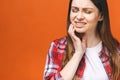 Young beautiful woman isolated on orange background suffering from severe toothache, feeling pain so strong that she is pressing Royalty Free Stock Photo