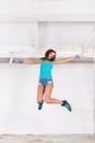 Young beautiful woman jump and paints the wall with white paint Royalty Free Stock Photo