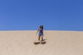 young beautiful woman jumping on the dunes in Portugal. Summertime, fun and holidays concept Royalty Free Stock Photo