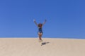 Young beautiful woman jumping on the dunes in Portugal. Summertime, fun and holidays concept Royalty Free Stock Photo