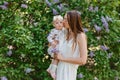 Young beautiful woman kisses baby girl in the cheek in summer Royalty Free Stock Photo