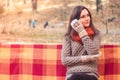 Young beautiful woman in a knitted sweater sitting on a bench in an autumn park Royalty Free Stock Photo