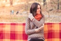Young beautiful woman in a knitted sweater sitting on a bench in an autumn park Royalty Free Stock Photo