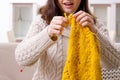 The young beautiful woman knitting at home