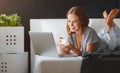 Young beautiful woman with laptop and cup of coffee in morni Royalty Free Stock Photo