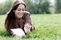 Young beautiful woman lays on a grass in park with a diary in ha Royalty Free Stock Photo