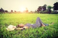 Young beautiful woman listening to music while lying down on green grass Royalty Free Stock Photo