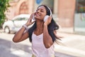 Young beautiful woman listening to music at street Royalty Free Stock Photo