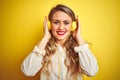 Young beautiful woman listening to music using headphones over yellow isolated background with a happy and cool smile on face Royalty Free Stock Photo