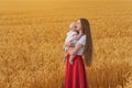 Young beautiful woman with little child in wheat field. Mother and her baby walks on field Royalty Free Stock Photo