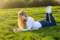 Young beautiful woman with long blond hair lies with a laptop on Royalty Free Stock Photo