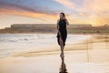 Young beautiful woman in long dress walking at la tejita beach at sunset Royalty Free Stock Photo