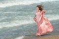 Young beautiful woman with long dress ,romantic mood on the beach with waves, Black sea side  Bulgaria Royalty Free Stock Photo