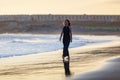 Young beautiful woman in long dress walking at la tejita beach at sunset Royalty Free Stock Photo