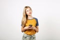 Beautiful natural blonde young woman posing, showing emotional facial expressions and making funny faces with smartphone