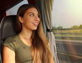 Young beautiful woman looking through the bus window. Happy bus passenger traveling sitting in a seat and looking through the Royalty Free Stock Photo