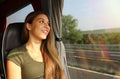 Young beautiful woman looking through the bus window. Happy bus passenger traveling sitting in a seat and looking through the Royalty Free Stock Photo