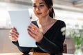 Young beautiful woman looking at menu deciding what to order in modern cafe. Royalty Free Stock Photo