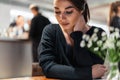 Young beautiful woman looking at menu deciding what to order in modern cafe. Royalty Free Stock Photo