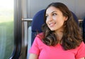 Young beautiful woman looking through the train window. Happy train passenger traveling sitting in a seat Royalty Free Stock Photo