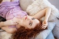 Young beautiful woman lying on bed, beautiful red hair, relaxation and relaxation concept Royalty Free Stock Photo