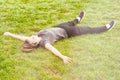 Young beautiful woman lying on grass with arms wide open Royalty Free Stock Photo