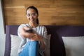 Young beautiful woman lying at her apartment living room on sofa couch holding remote control watching television. Happy and Royalty Free Stock Photo