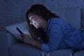 Young beautiful woman lying on home couch using mobile phone internet addiction concept