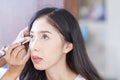 Young beautiful woman with Makeup Brush. Two friends making up in the cafe. Asian girl. Friends are mascara brush Royalty Free Stock Photo