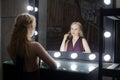 Young beautiful woman with makeup and reflection in dressing room Royalty Free Stock Photo