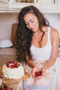 Young beautiful woman making cake at the kitchen