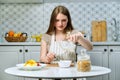 Young beautiful woman making fruit salad in kitchen Royalty Free Stock Photo