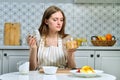 Young beautiful woman making fruit salad in kitchen Royalty Free Stock Photo