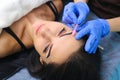 Young beautiful woman making permanent makeup in cosmetology salon. Royalty Free Stock Photo