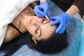 Young beautiful woman making permanent makeup in cosmetology salon. Royalty Free Stock Photo