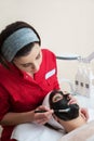 Young beautiful woman in a mask for the face of the therapeutic black mud in a beauty salon Royalty Free Stock Photo