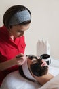 Young beautiful woman in a mask for the face of the therapeutic black mud in a beauty salon Royalty Free Stock Photo