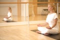 Young beautiful woman meditating in lotus pose sitting on the fl Royalty Free Stock Photo